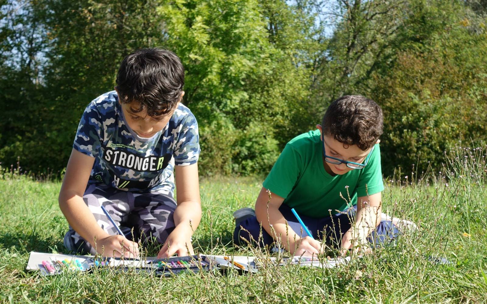 Zwei Jungen lernen draussen in der Natur.