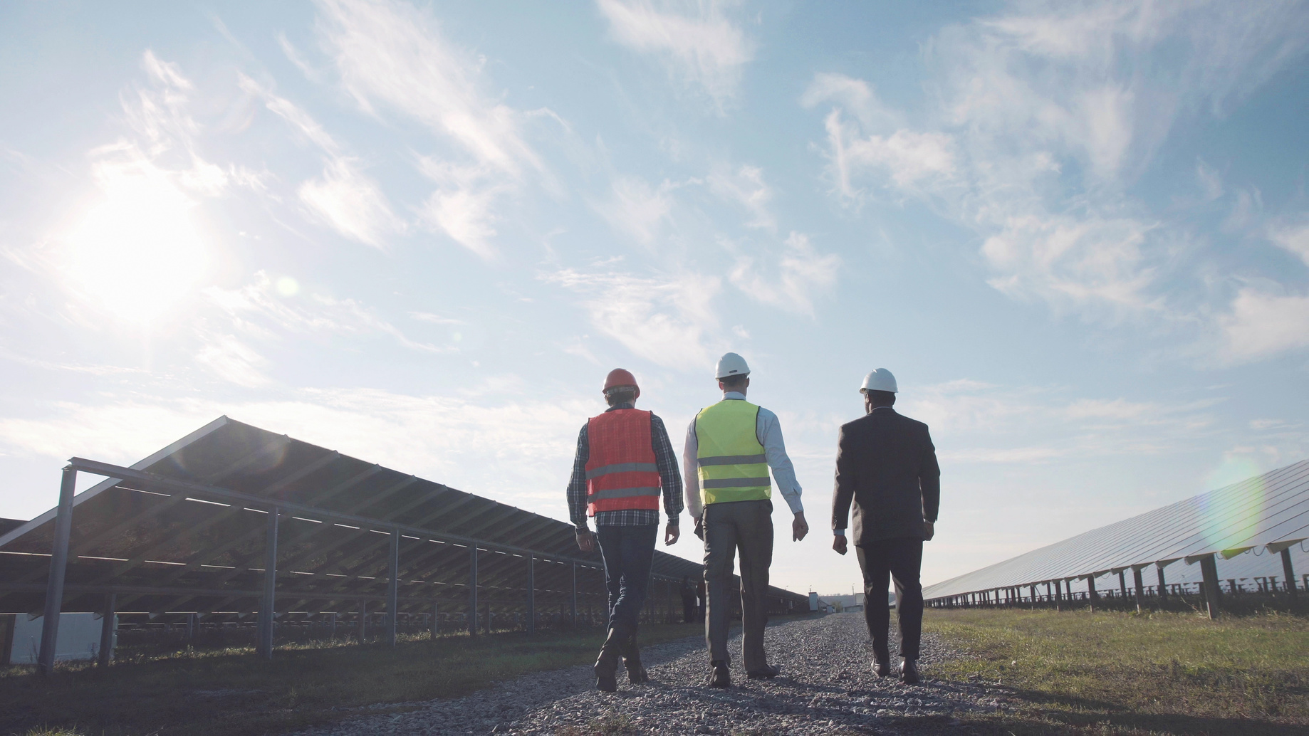 Drei Männer begutachten eine Solaranlage