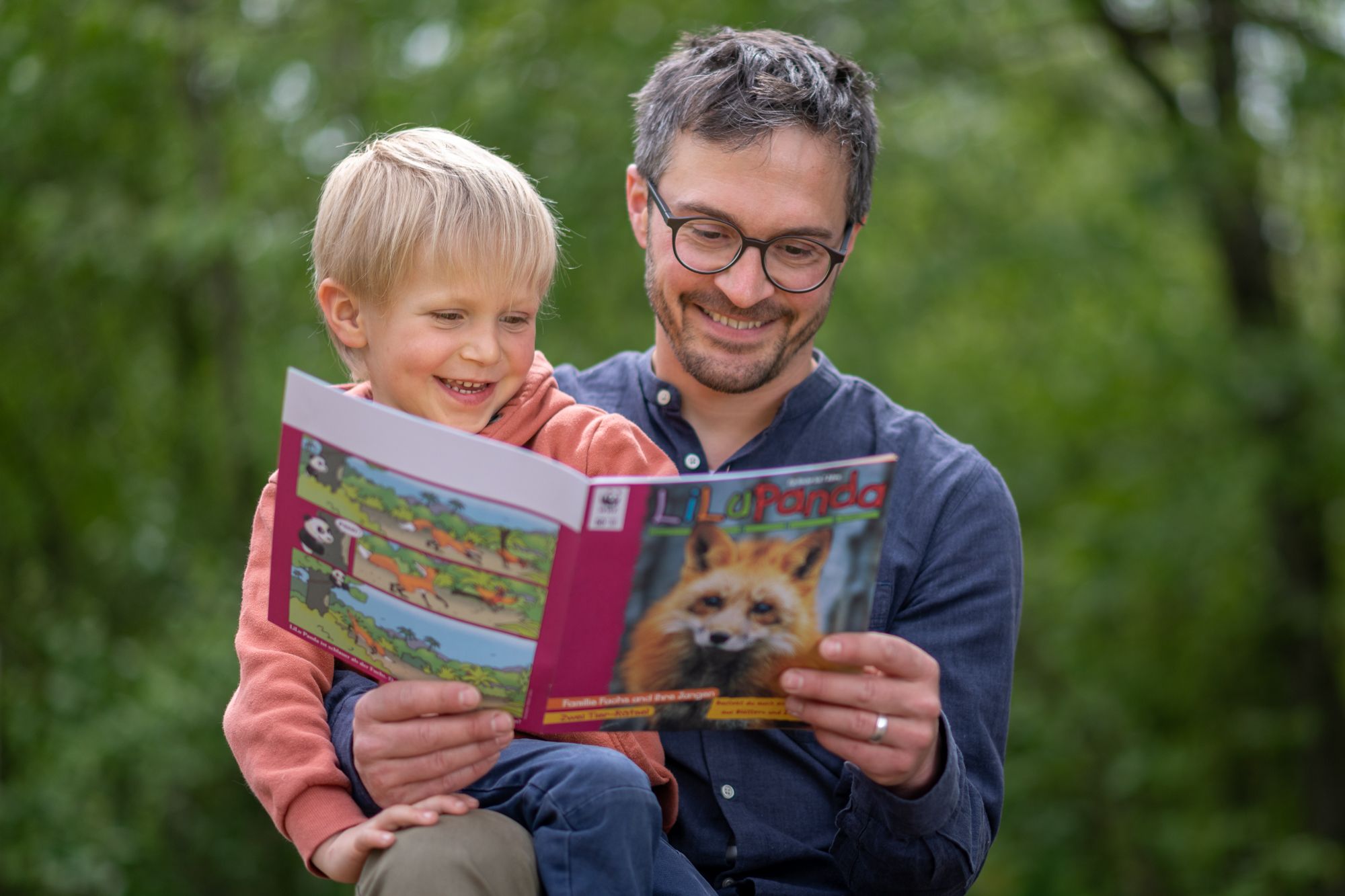 A father and his toddler son reading the LiLu Panda magazine together