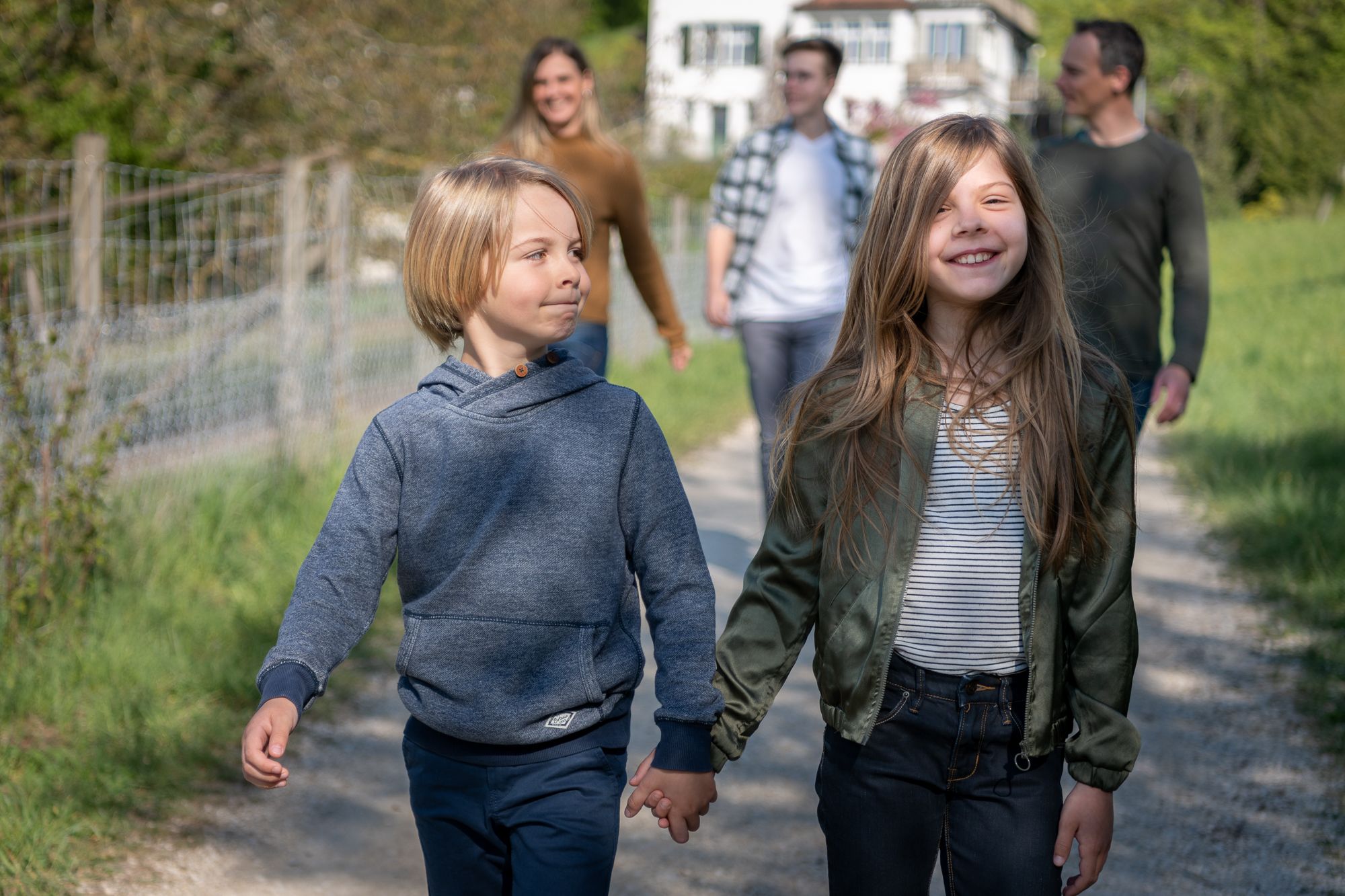 A family going for a walk with brother and sister walking hand in hand