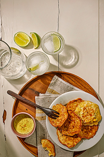 Einige Plätzchen auf einem Teller und daneben zwei Gläser und ein Wasserkrug