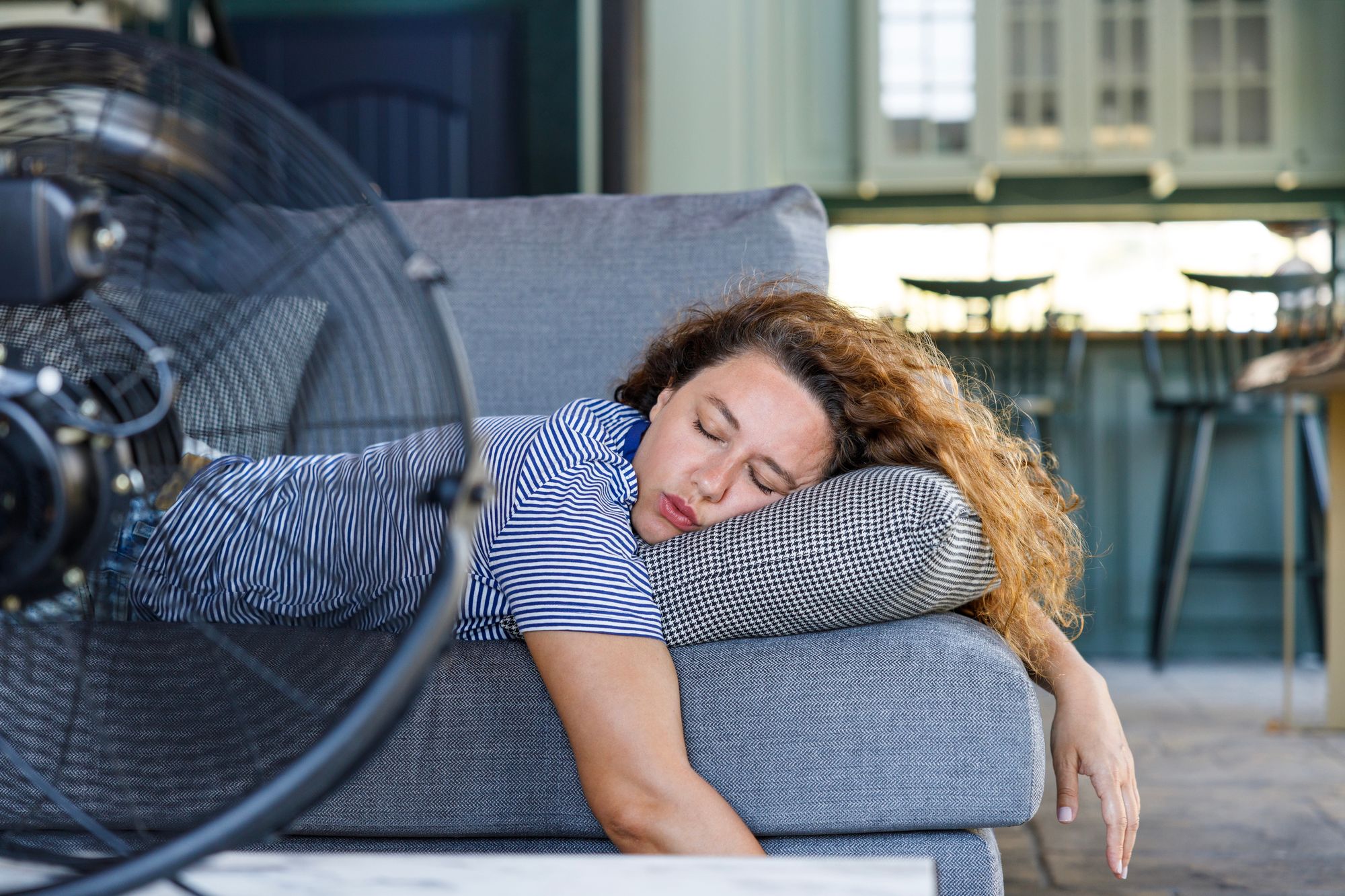 Woman sleeps in front of fan (heat)