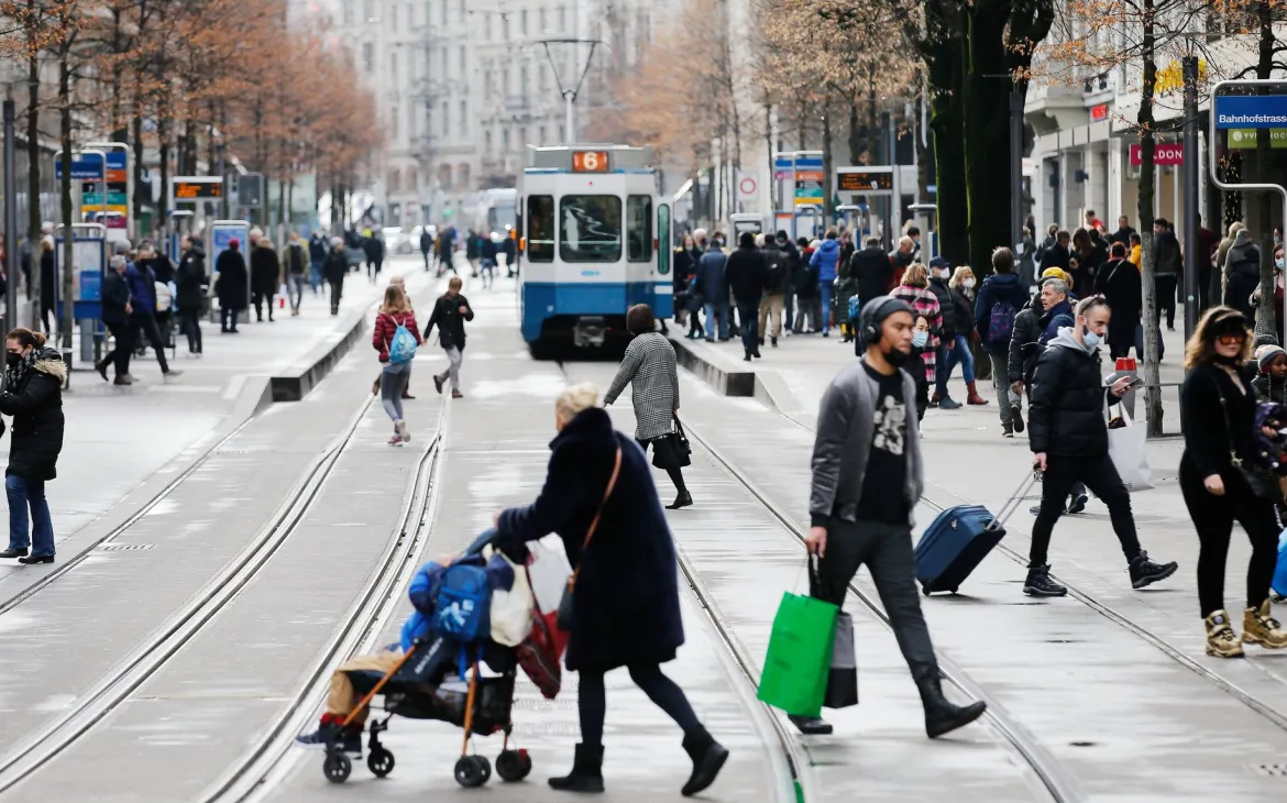 Passanten gehen über Bahnhofstrasse in Zürich, im Hintergrund ein Tram