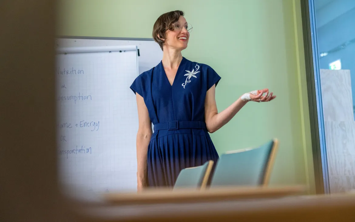 Woman speaks in front of board