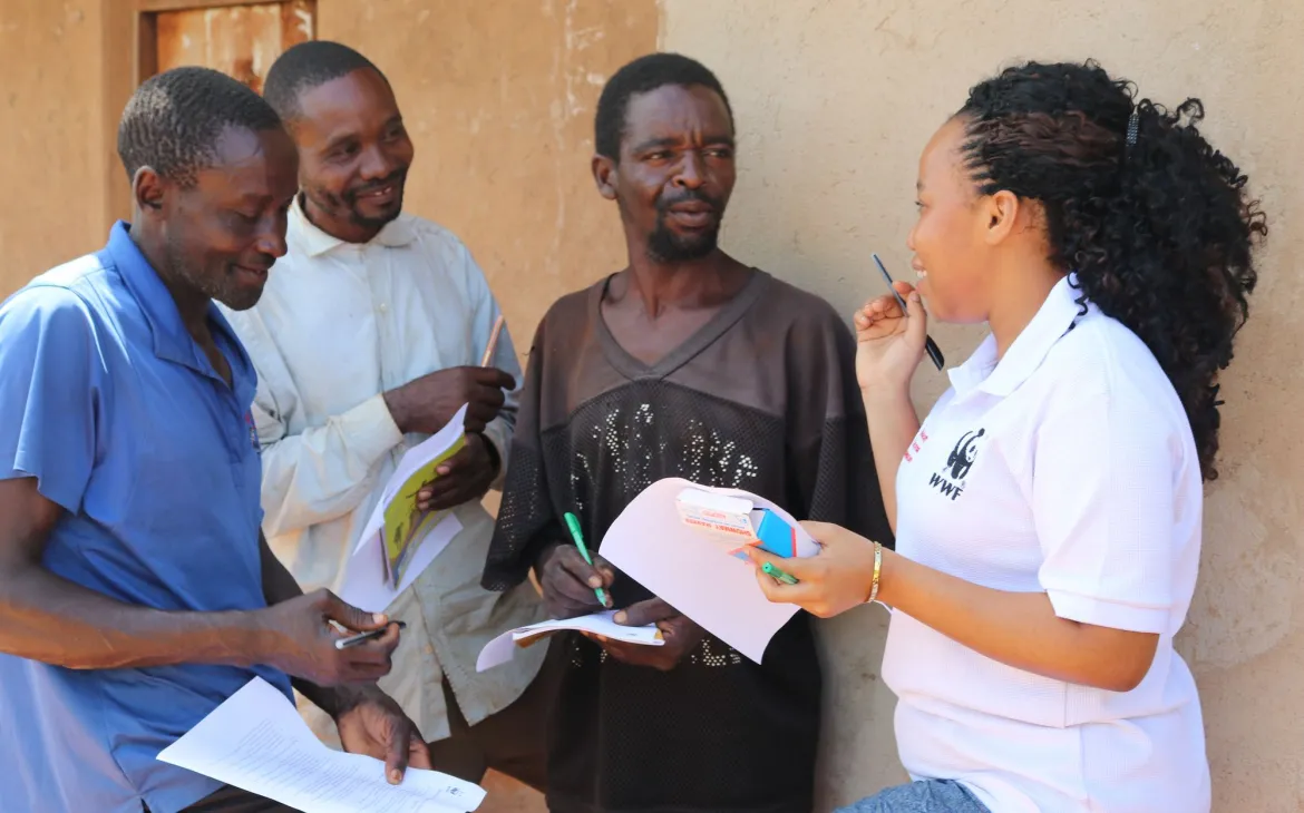 Eine Frau im WWF Tshirt spricht zu einer Gruppe Männer