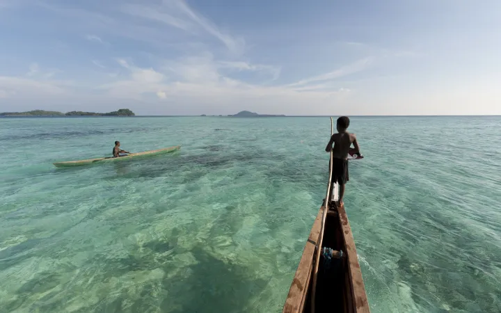 Junge auf Gemeinde-Kanu in Papa Neuguinea