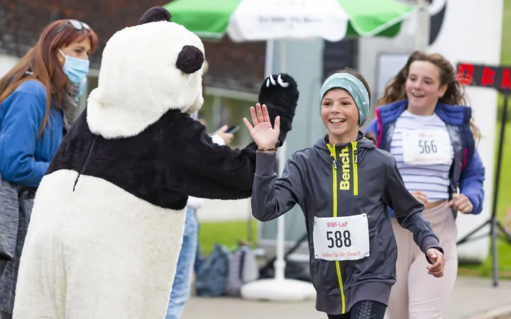 Verkleideter Panda an einem WWF-Lauf mit Kindern