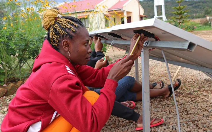 Zwei Studierende die an der Istallation eines Solarpanel arbeiten