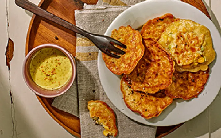 Einige Plätzchen auf einem Teller und daneben zwei Gläser und ein Wasserkrug