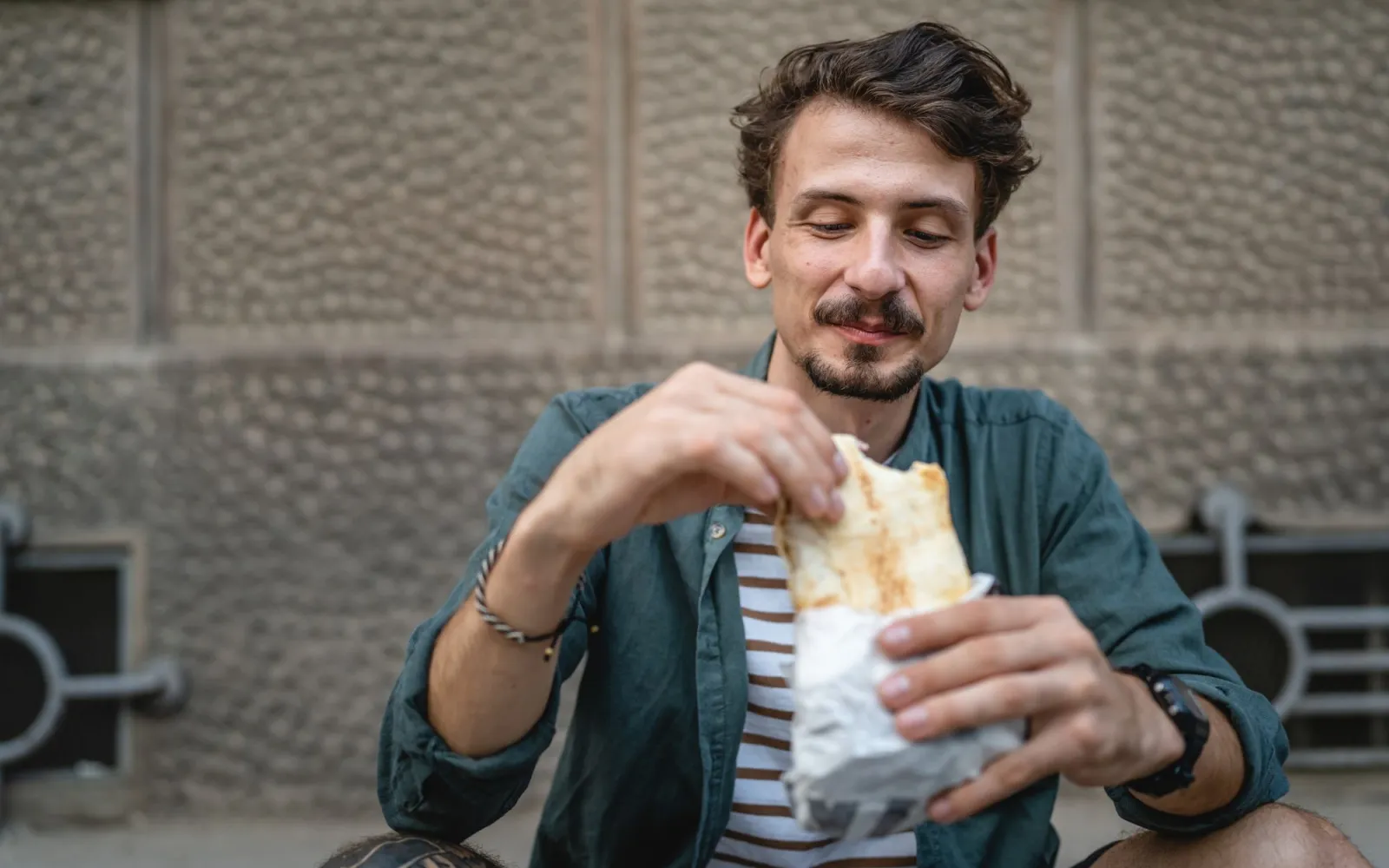 Mann isst Döner im sitzen