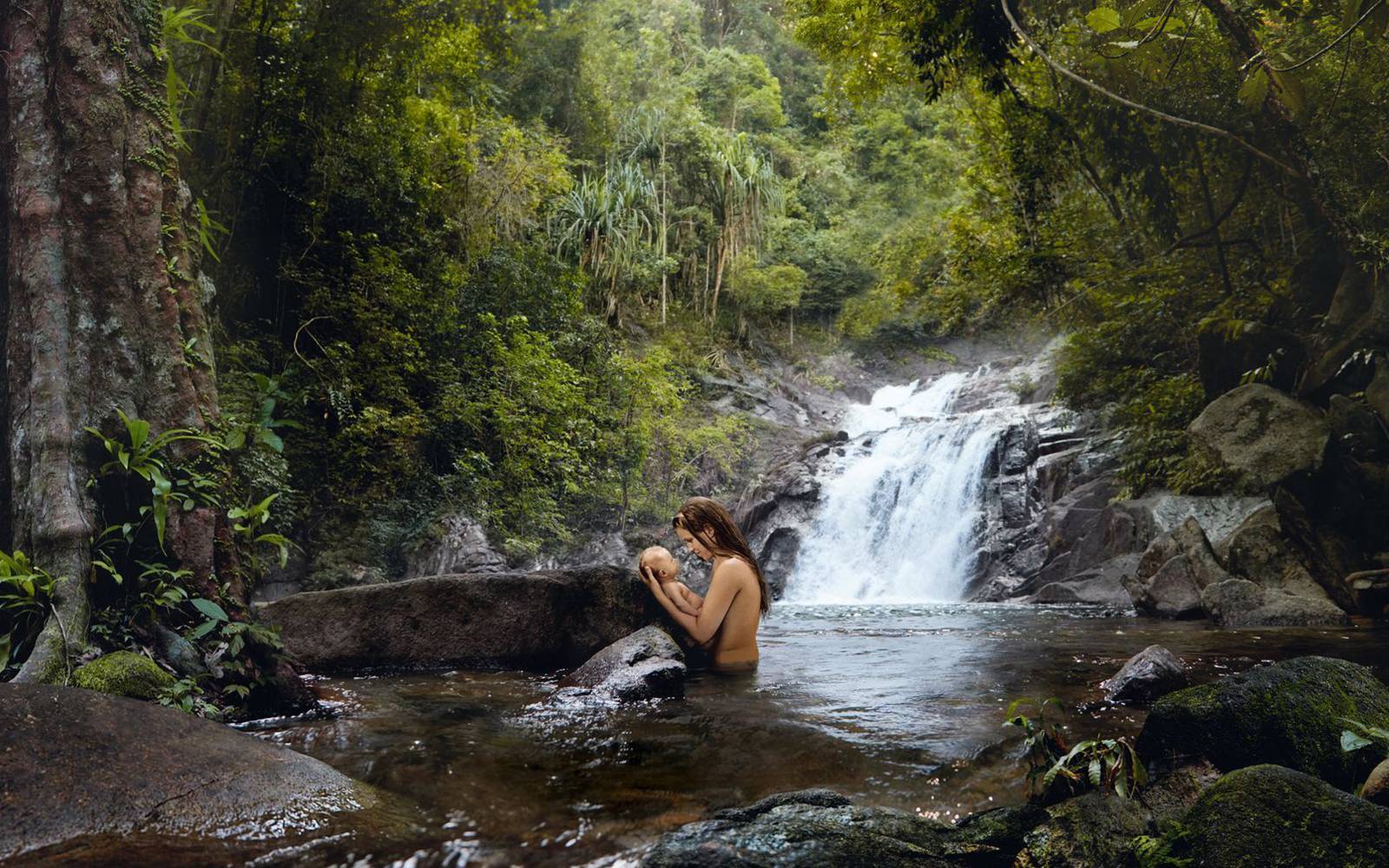 Frau mit Baby bei einem Wasserfall