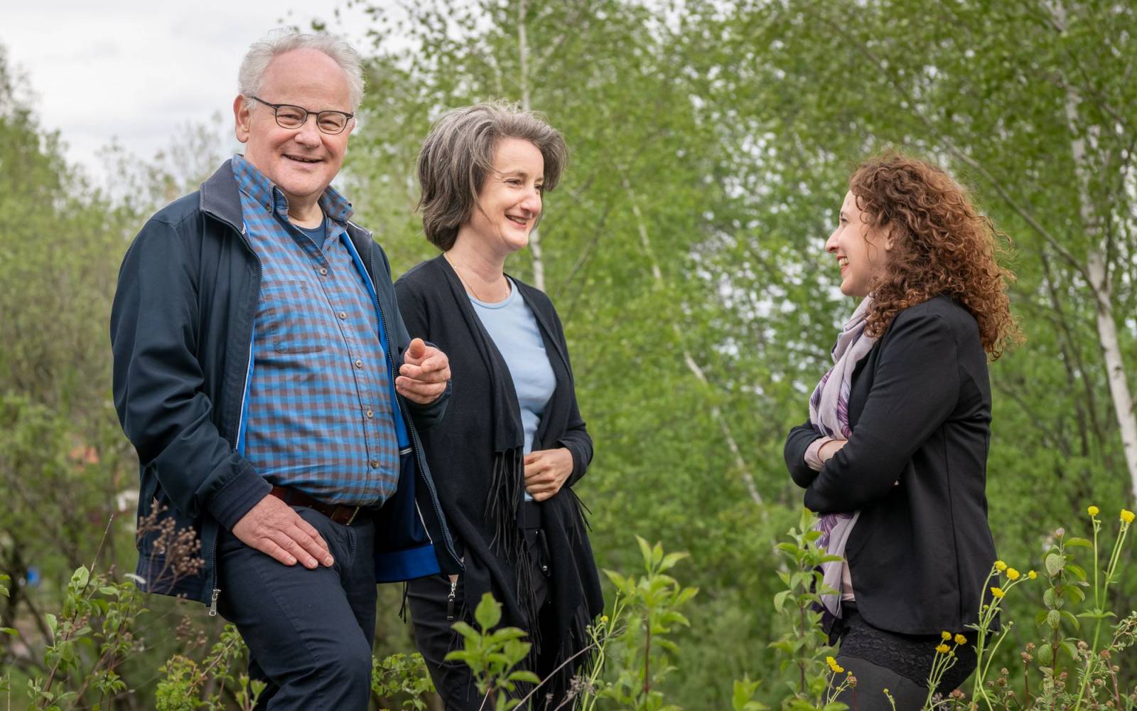 One gentleman and two ladies in nature chatting