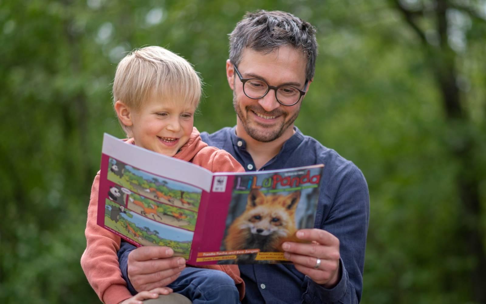 A father and his toddler son reading the LiLu Panda magazine together