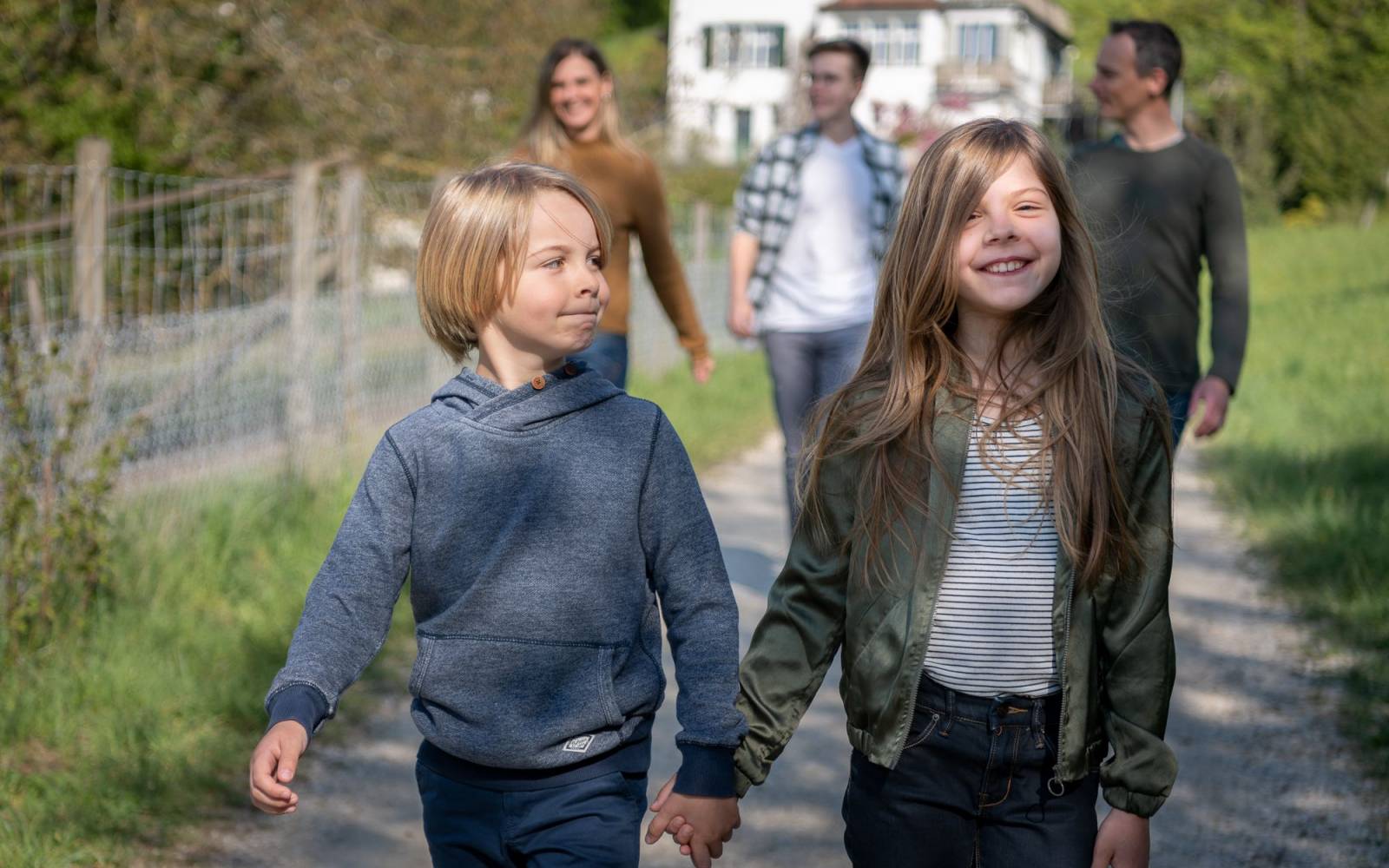 A family going for a walk with brother and sister walking hand in hand