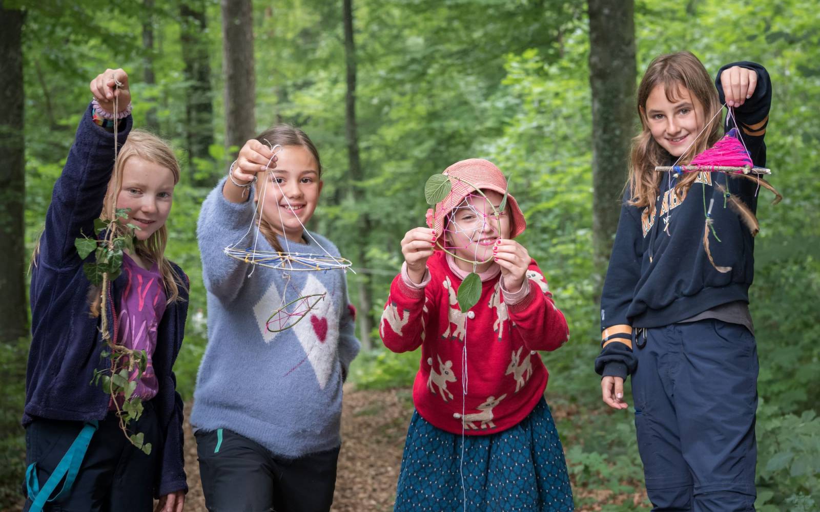 Vier Mädchen zeigen ihre Traumfänger mit Naturmaterialien, Schweiz.