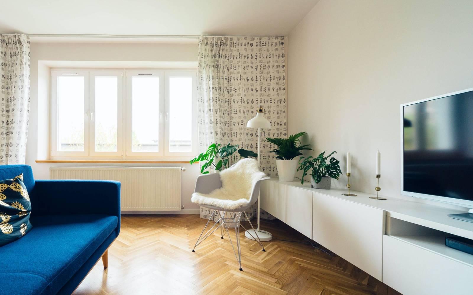 Wohnzimmer von innen mit Couch, Stuhl und Fernseher