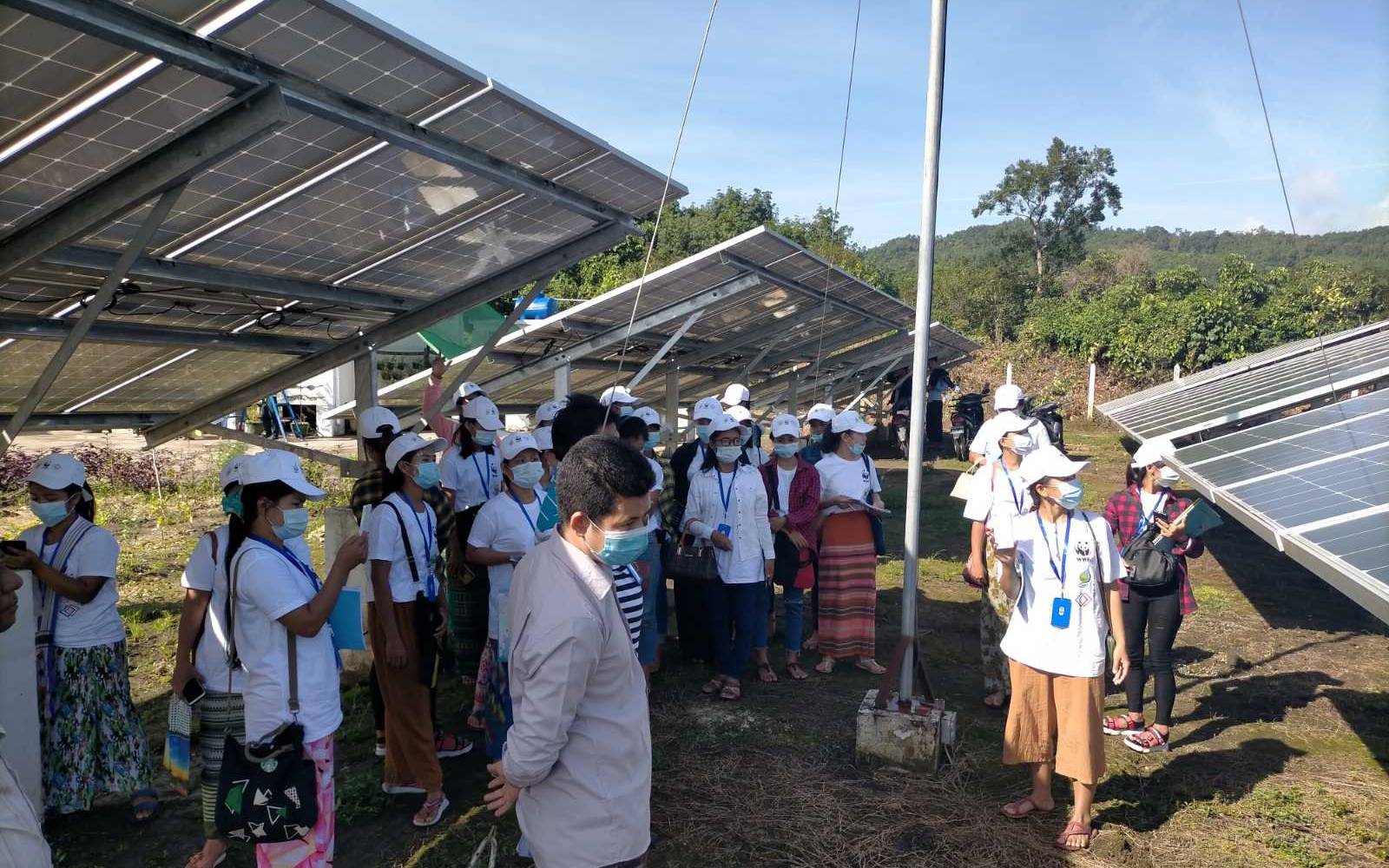 Trainees inspizieren Solarzellen in Myanmar