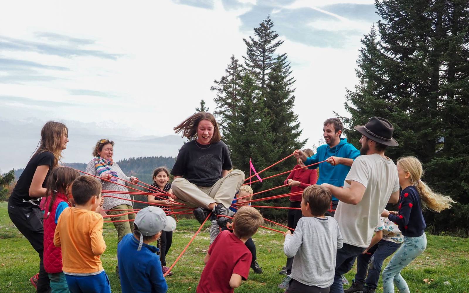 Die Lagerleitenden spielen ein Spiel mit den Kindern in der Natur