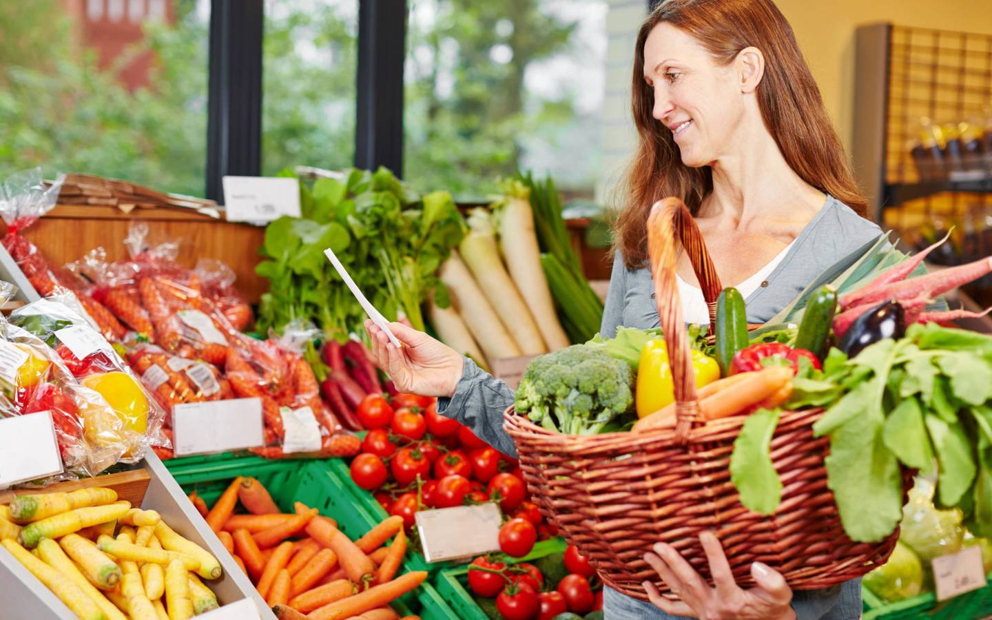 Femme avec liste d'achats acheter des légumes