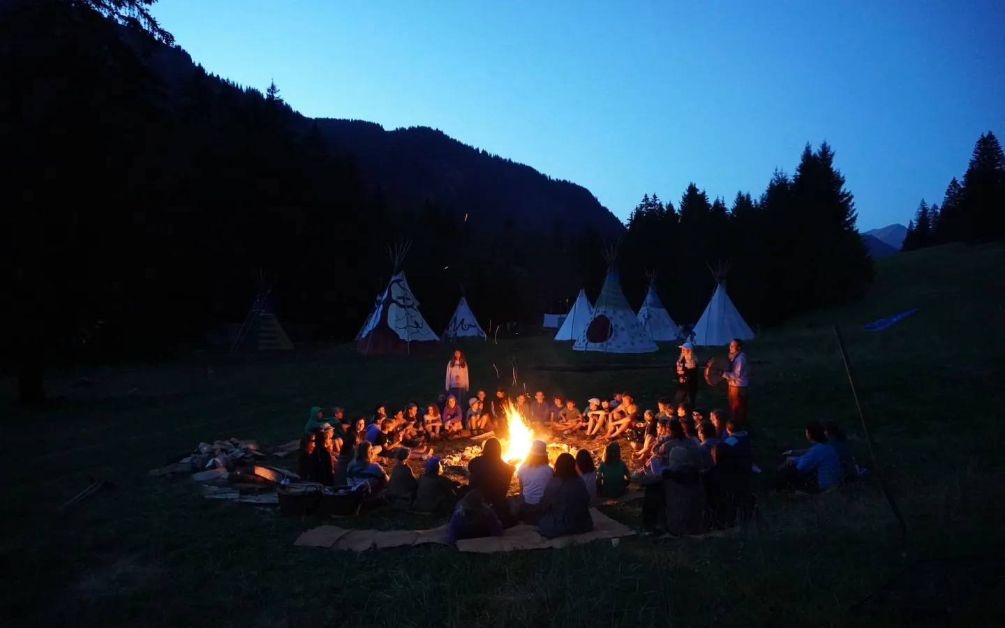 kids sitting around camp fire