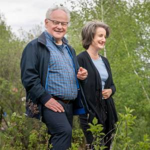 One gentleman and two ladies in nature chatting