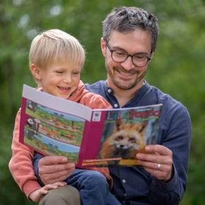 A father and his toddler son reading the LiLu Panda magazine together
