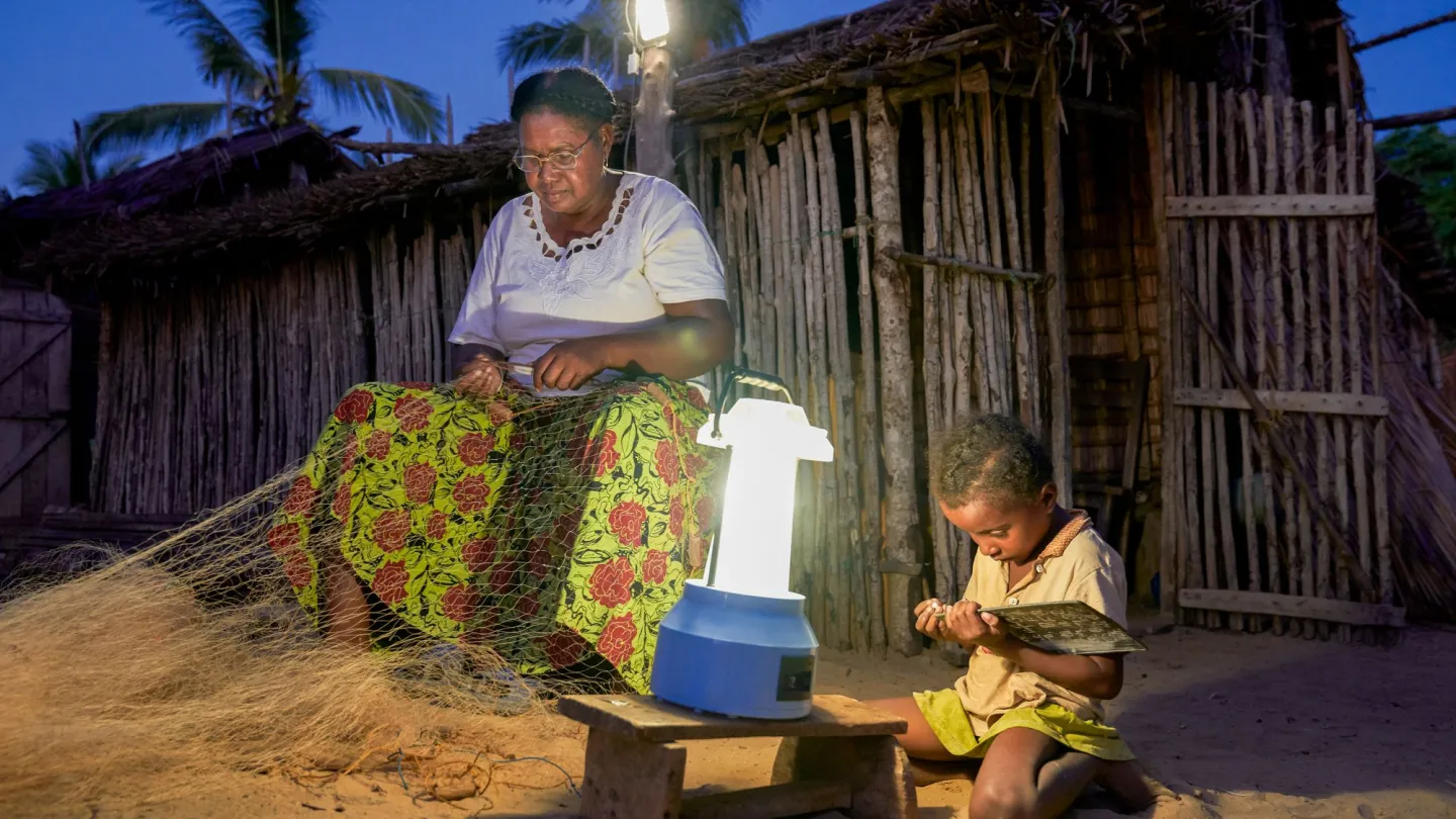 Frau flickt Fischernetz im Licht einer Solarlampe. Barefoot College Madagaskar