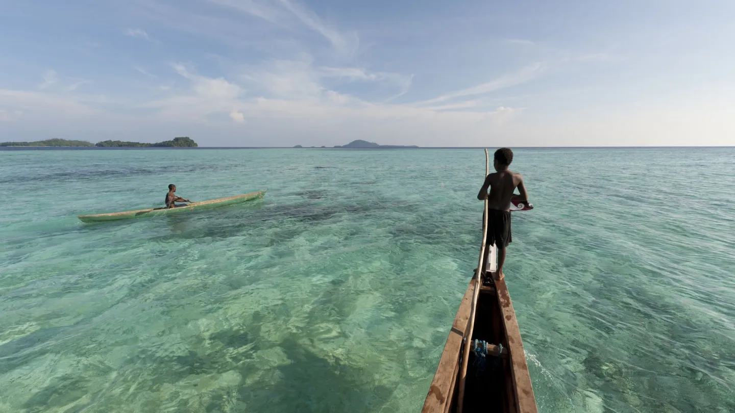 Junge auf Gemeinde-Kanu in Papa Neuguinea