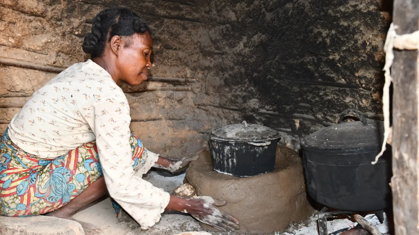 Woman building energy efficient stove Kamado in Madagascar
