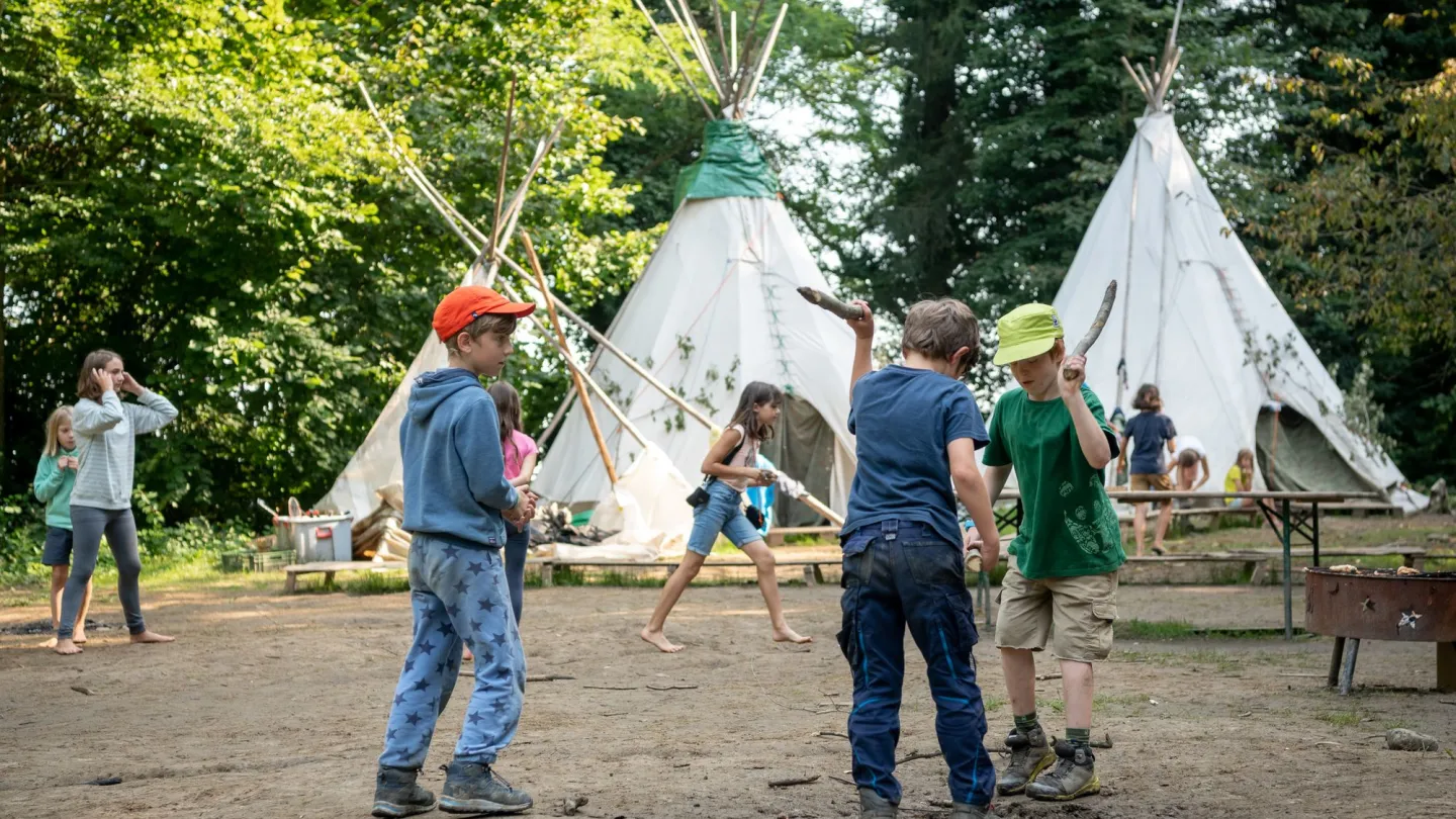 Jungs spielen vor den Tipis, Tipilager in der Schweiz