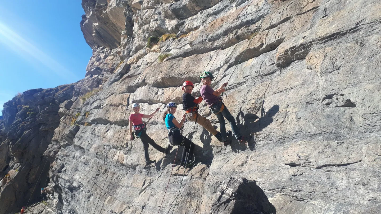 Vier Kinder hängen in einer Kletterwand, Schweiz