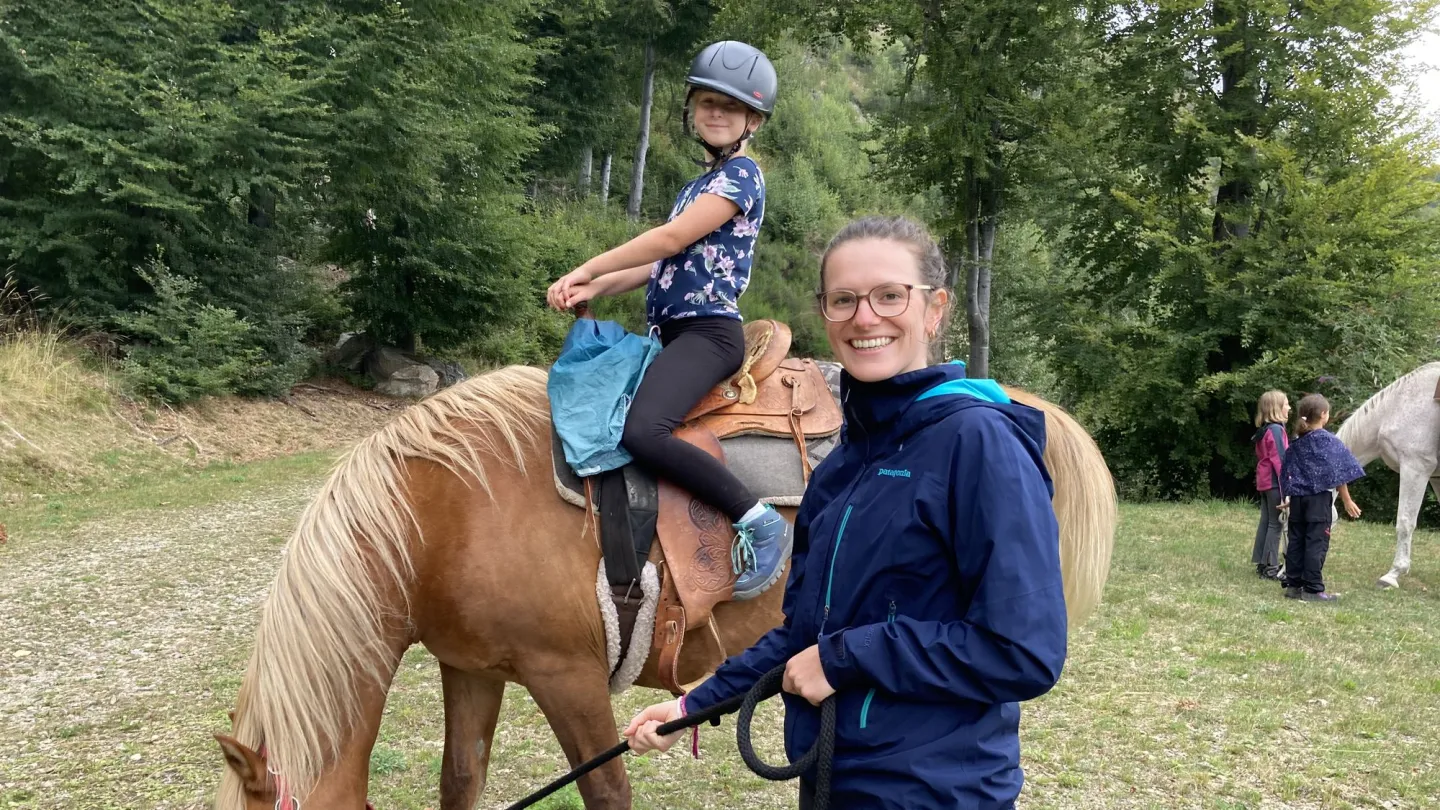 Eine Lagerleiterin führt das Pferd.