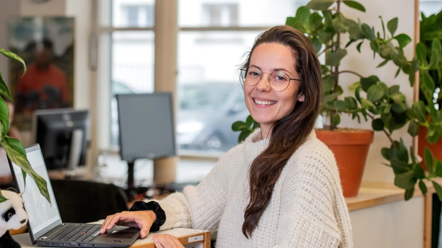 woman sitting at computer smiling at camera