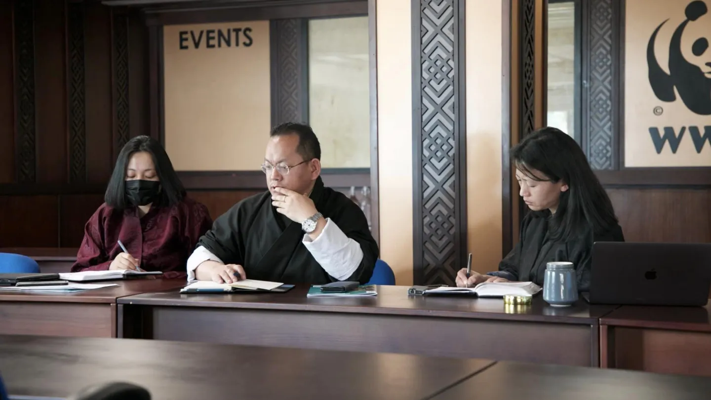 Three Peoples sitting on a table in a room in Bhutan