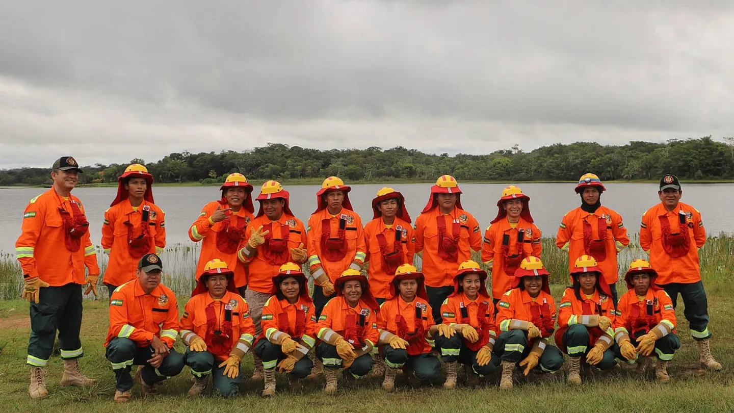 Eine Gruppe Feuerwehrmänner in orangen Schutzanzügen