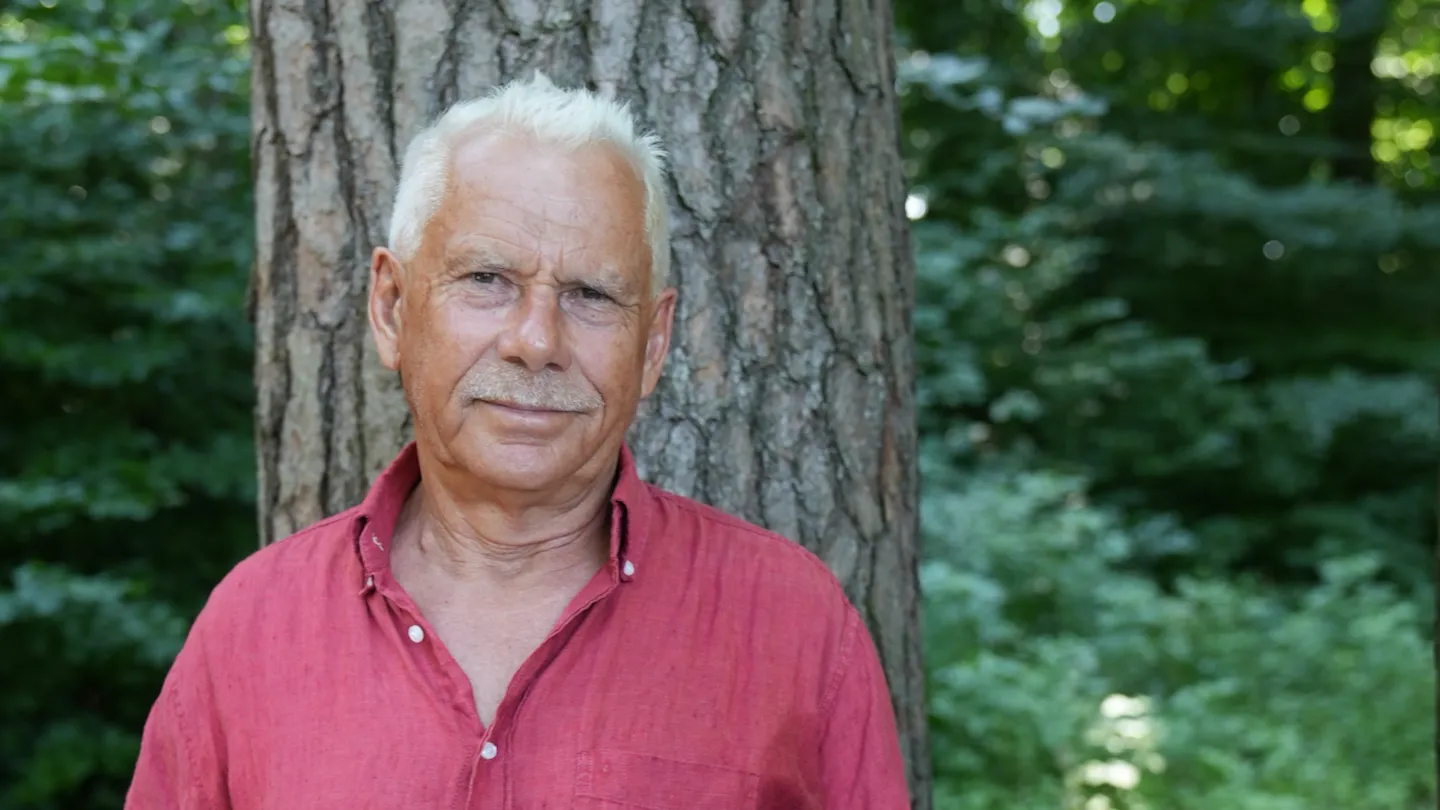 Portrait von Hans Vögeli vor einem Baum im Wald stehend