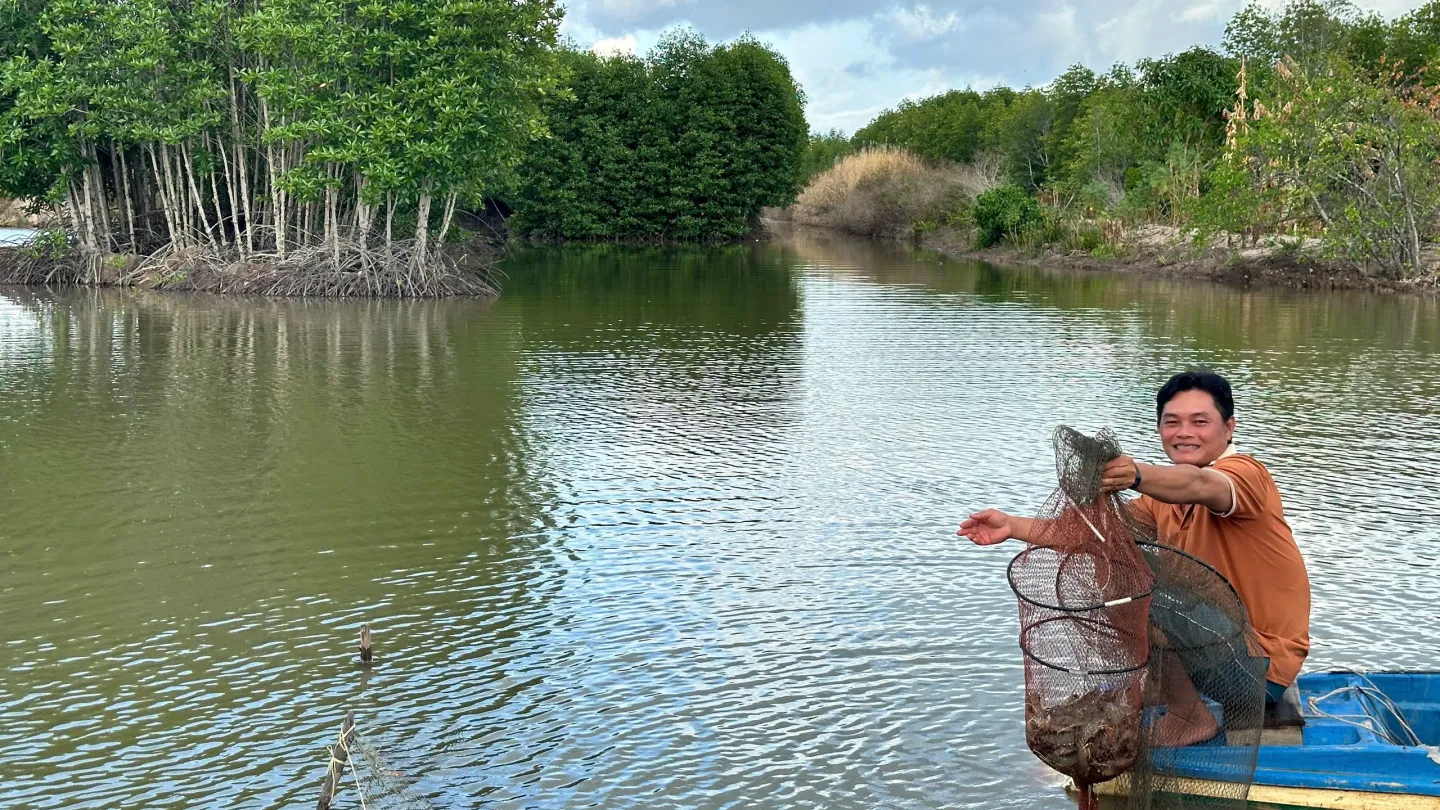 Vietnam farmer harvesting shrimp on a river
